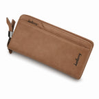 A tan leather zip-around wallet with a wrist strap and silver-tone metal hardware, shown on a plain white background. The brand name 'Juellett' is embossed on the front.
